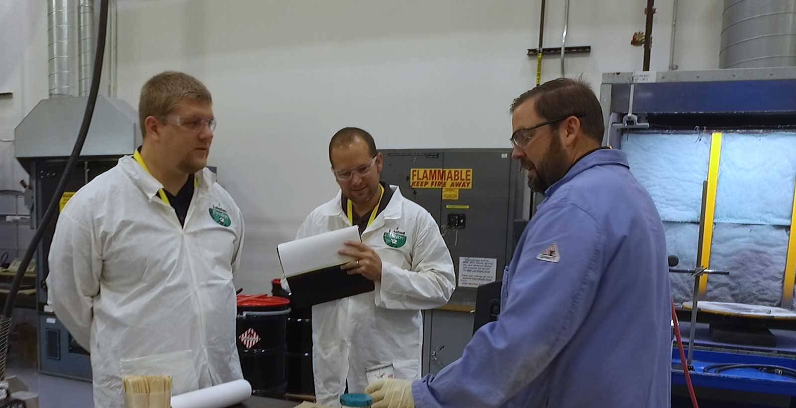 科学家在学习Chemlok粘合剂的实验室中与两个人交谈